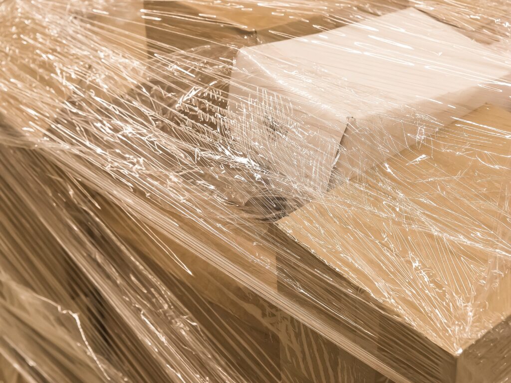 Cardboard boxes wrapped with plastic film to protect from dust before the moving day